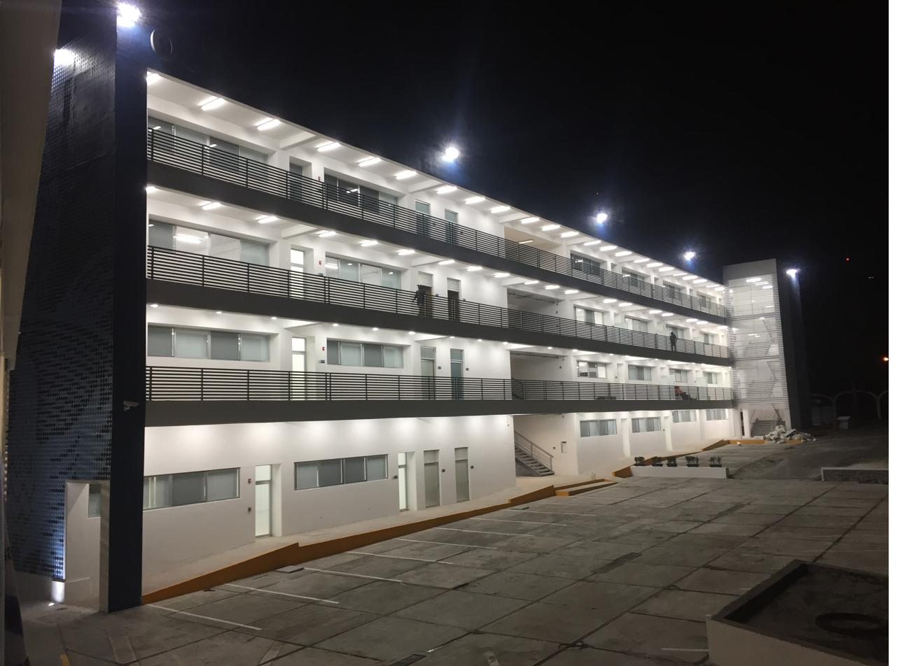 Edificio académico de cuatro niveles iluminado de noche