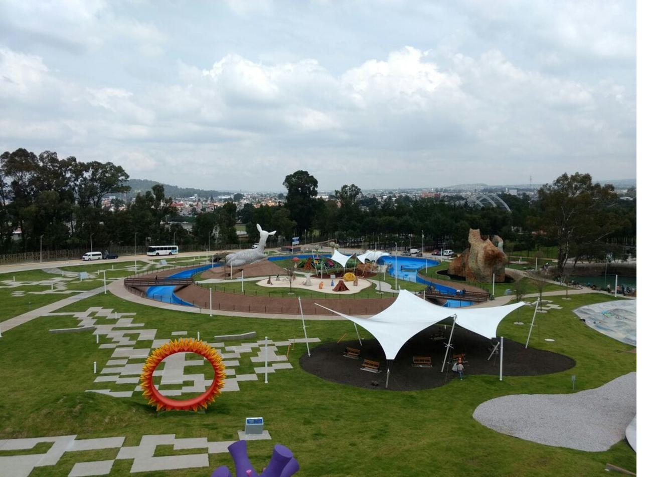 Vista aérea de parque urbano con velarias blancas y senderos